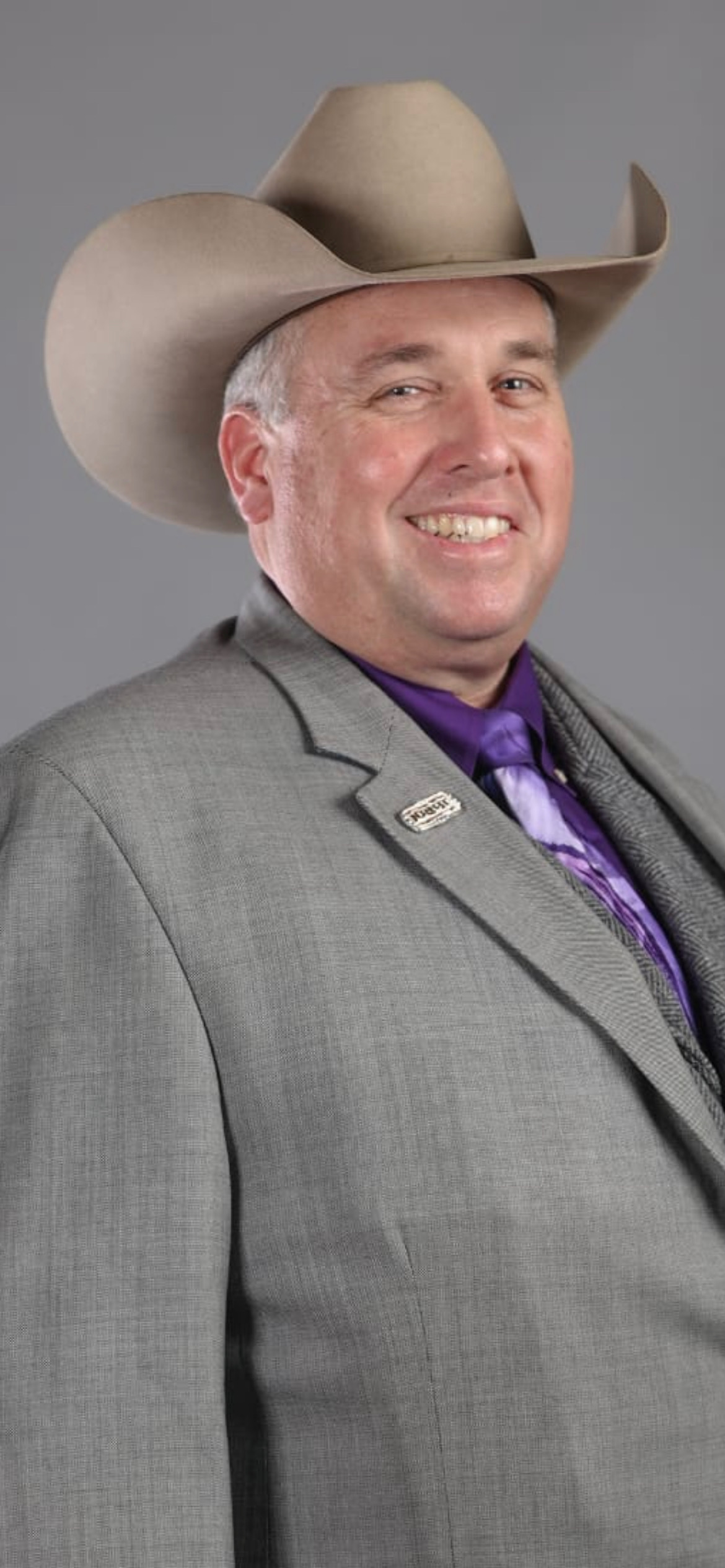 Portrait of Ed “Hoot” Bricker in a cowboy hat and grey suit